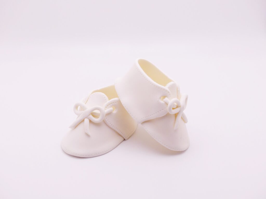 White baby shoes with small bow on the front.