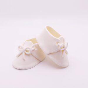 White baby shoes with small bow on the front.