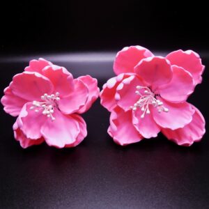 A set of 1 small and 1 medium, pink colored peonies with white stamens.